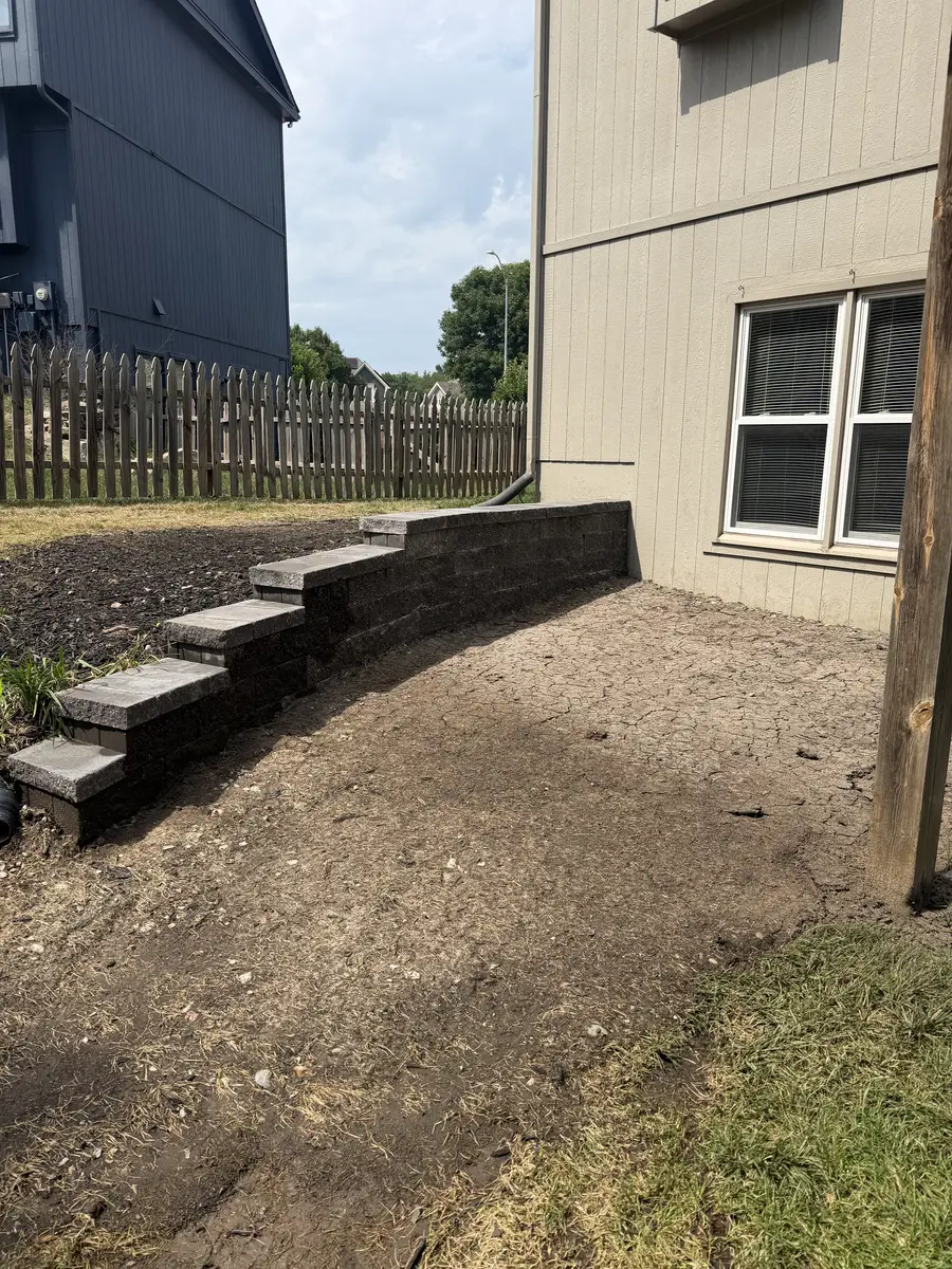 New segmental block retaining wall with integrated steps alongside home — North Kansas City MO