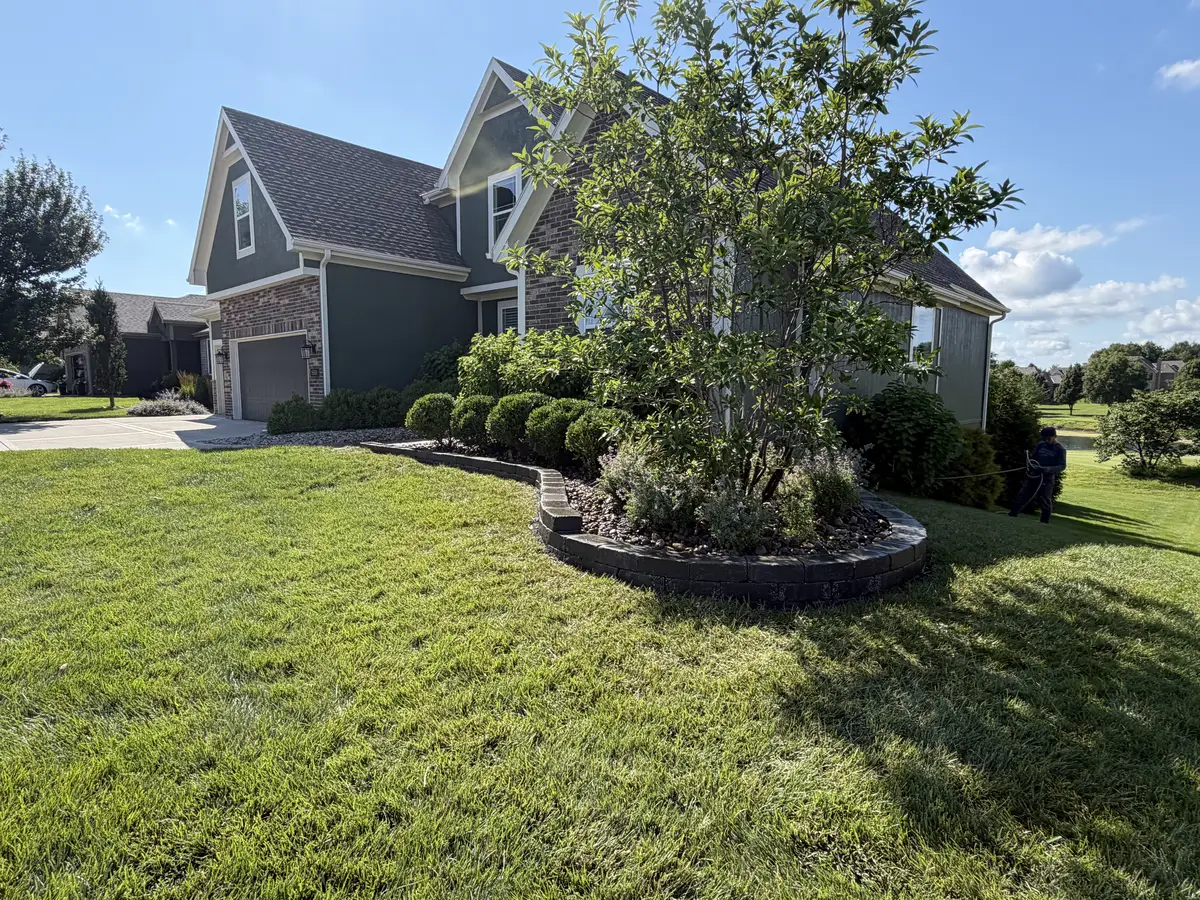 Curb appeal transformation with curved stone landscape bed and manicured lawn — Liberty MO