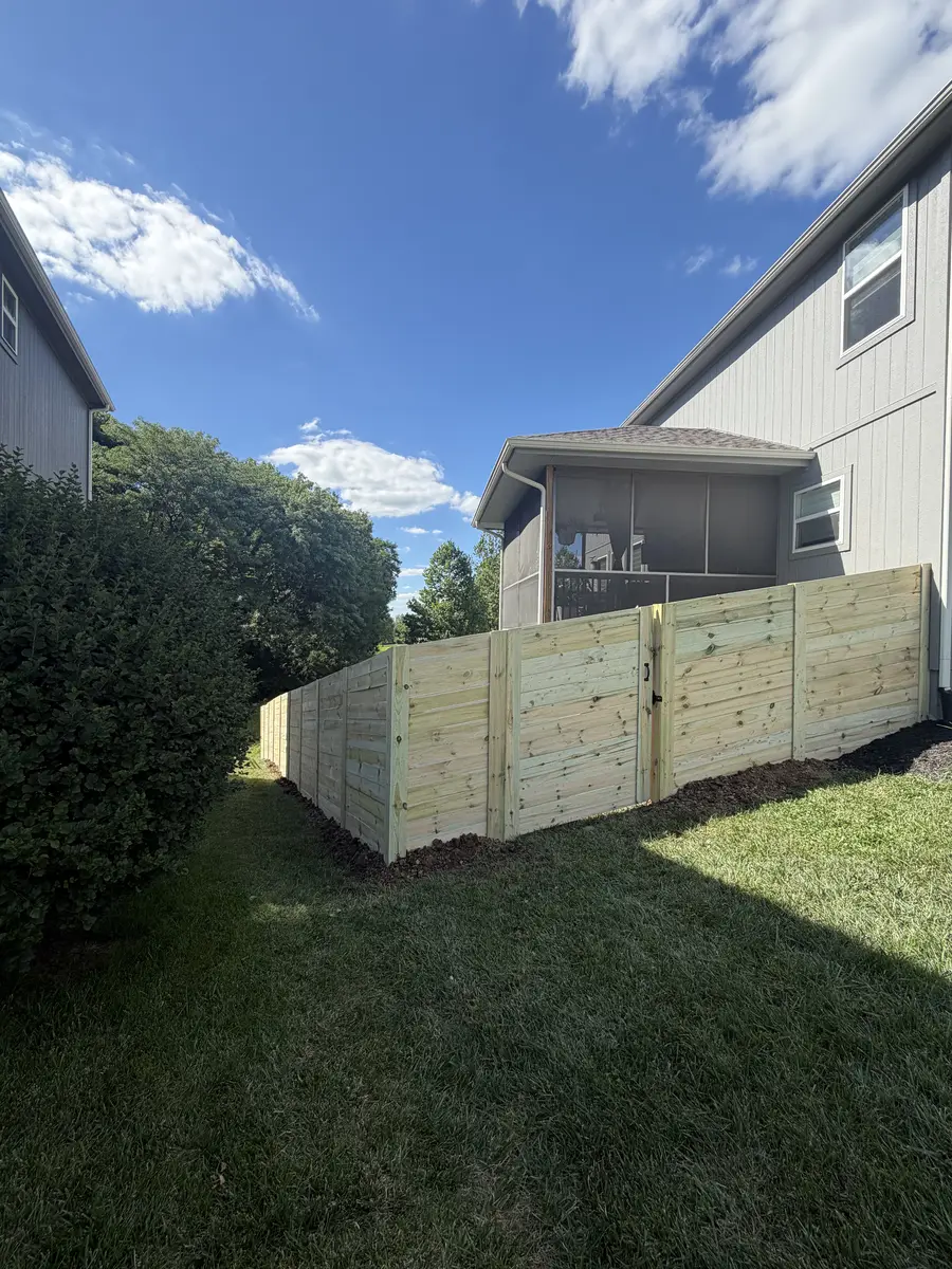 New horizontal cedar board privacy fence with gate in residential backyard — Smithville MO