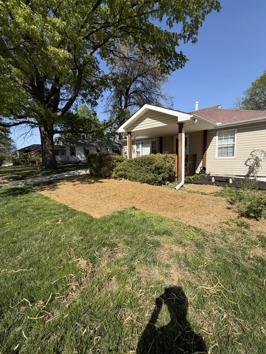 Fresh lawn seeding with straw erosion cover applied to bare front yard patch — North Kansas City MO