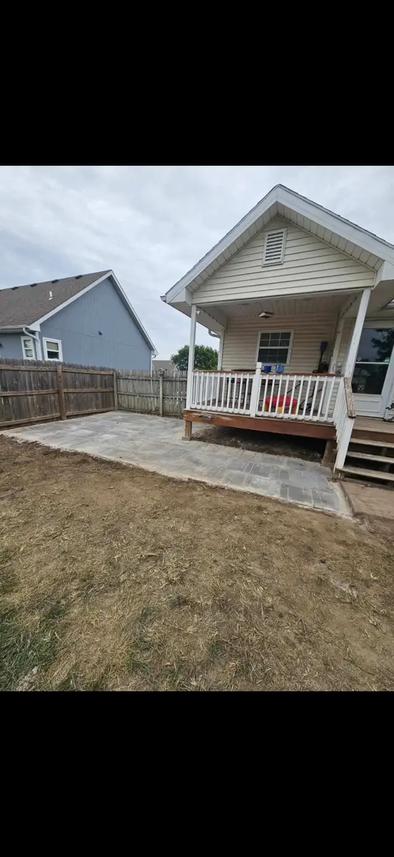 New interlocking stone paver patio installed beside front porch — North Kansas City MO