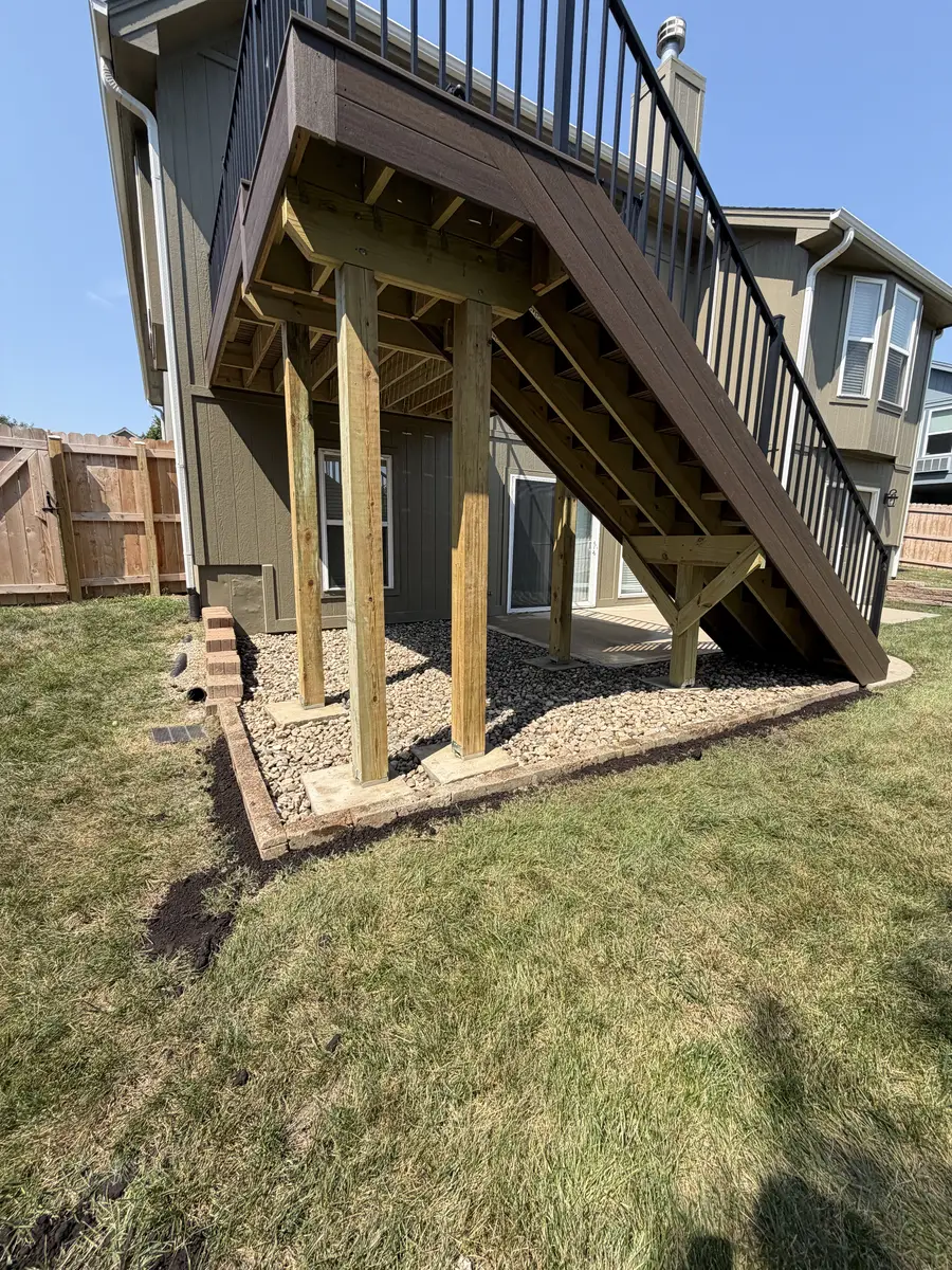 Under-deck area finished with river rock, gravel, and segmental block border — Platte City MO